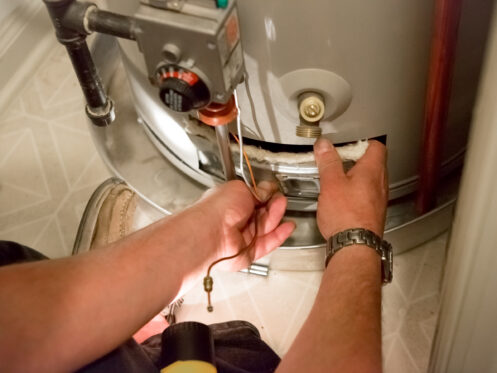 A plumber working on a water heater